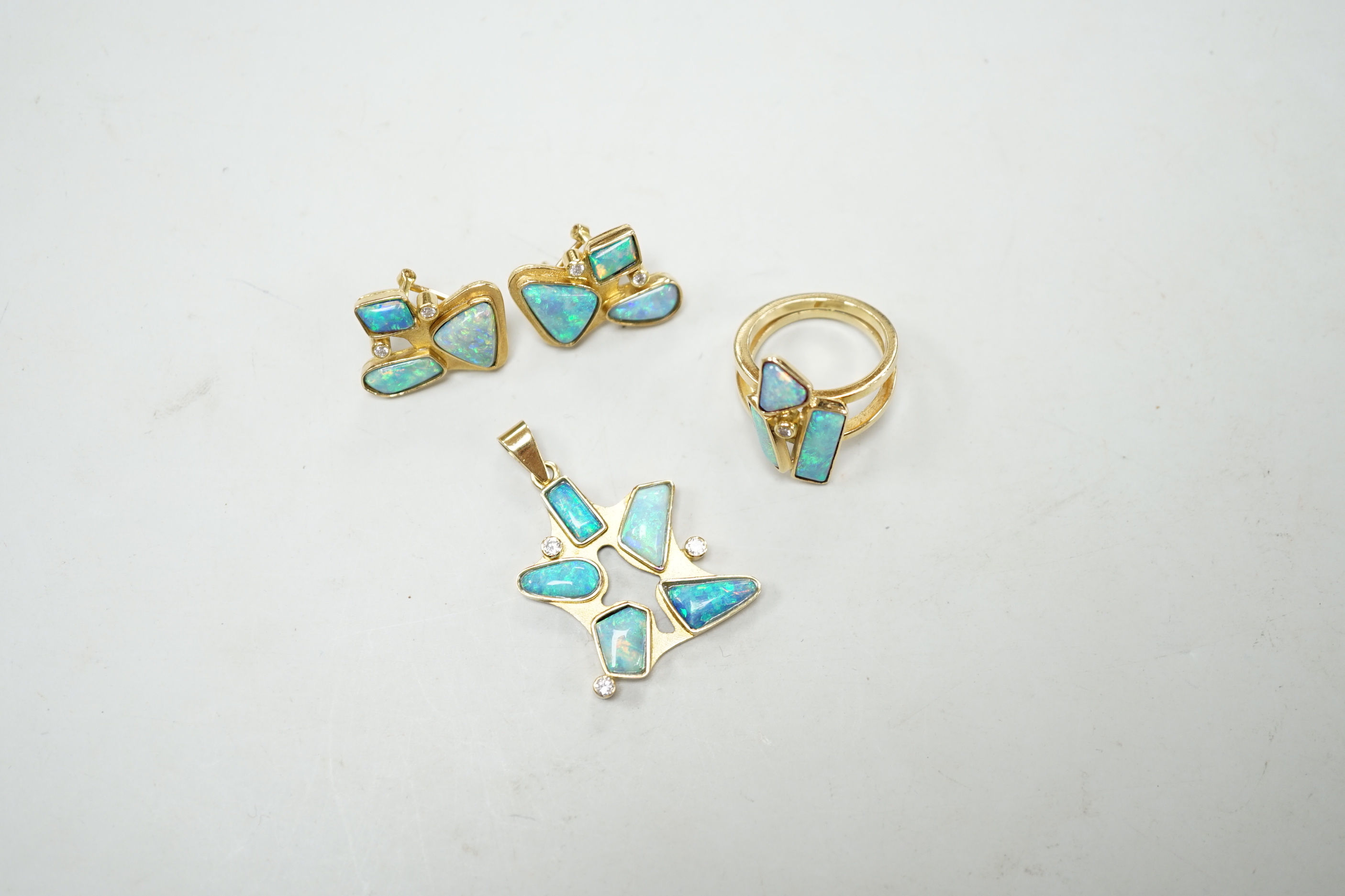 A modernist suite of 750 yellow metal, opal doublet? and diamond cluster set jewellery, comprising a pendant (overall 37mm), dress ring and pair of earrings, gross weight 24 grams.